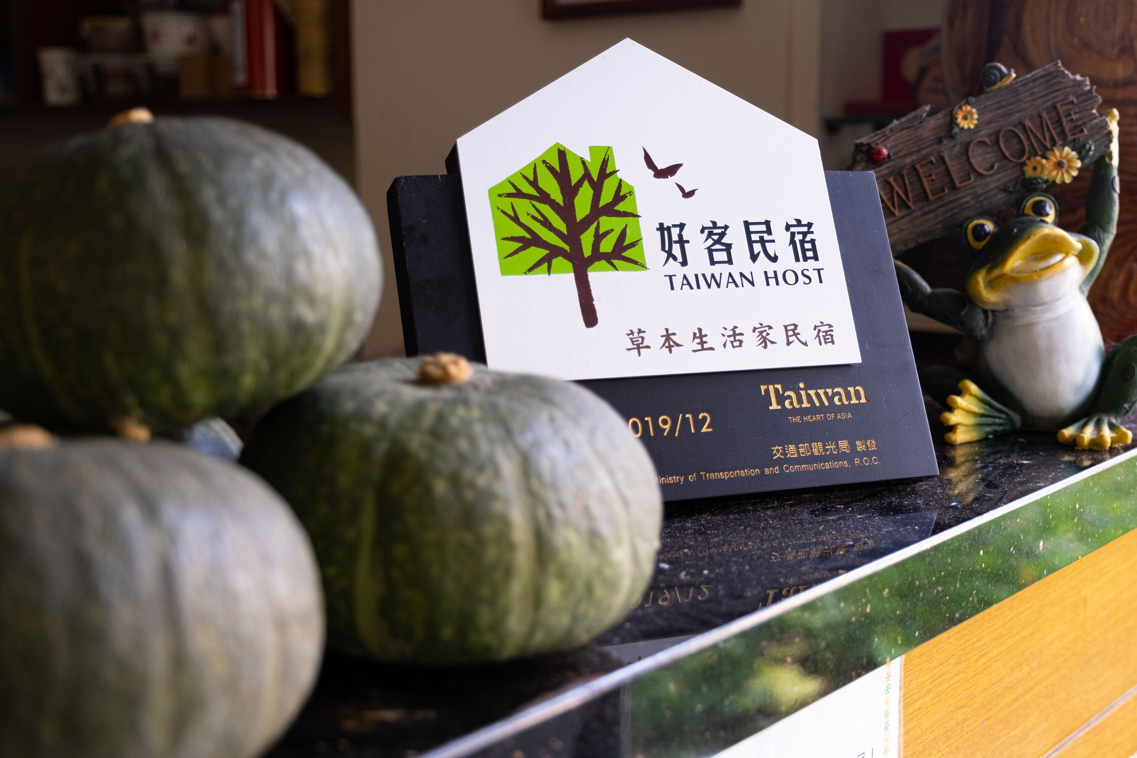 Un letrero con el logotipo de un árbol e indicación de que es un establecimiento para hospedaje en Taiwán.
