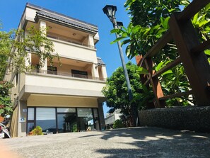 Un edificio de varios pisos con techo plano, ventanas grandes y un balcón.