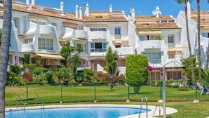 A pool area with a clear view of a white building with balconies and a tiled roof. - J07 Jardines 4 - Apartment with sea views (Sitio de Calahonda)