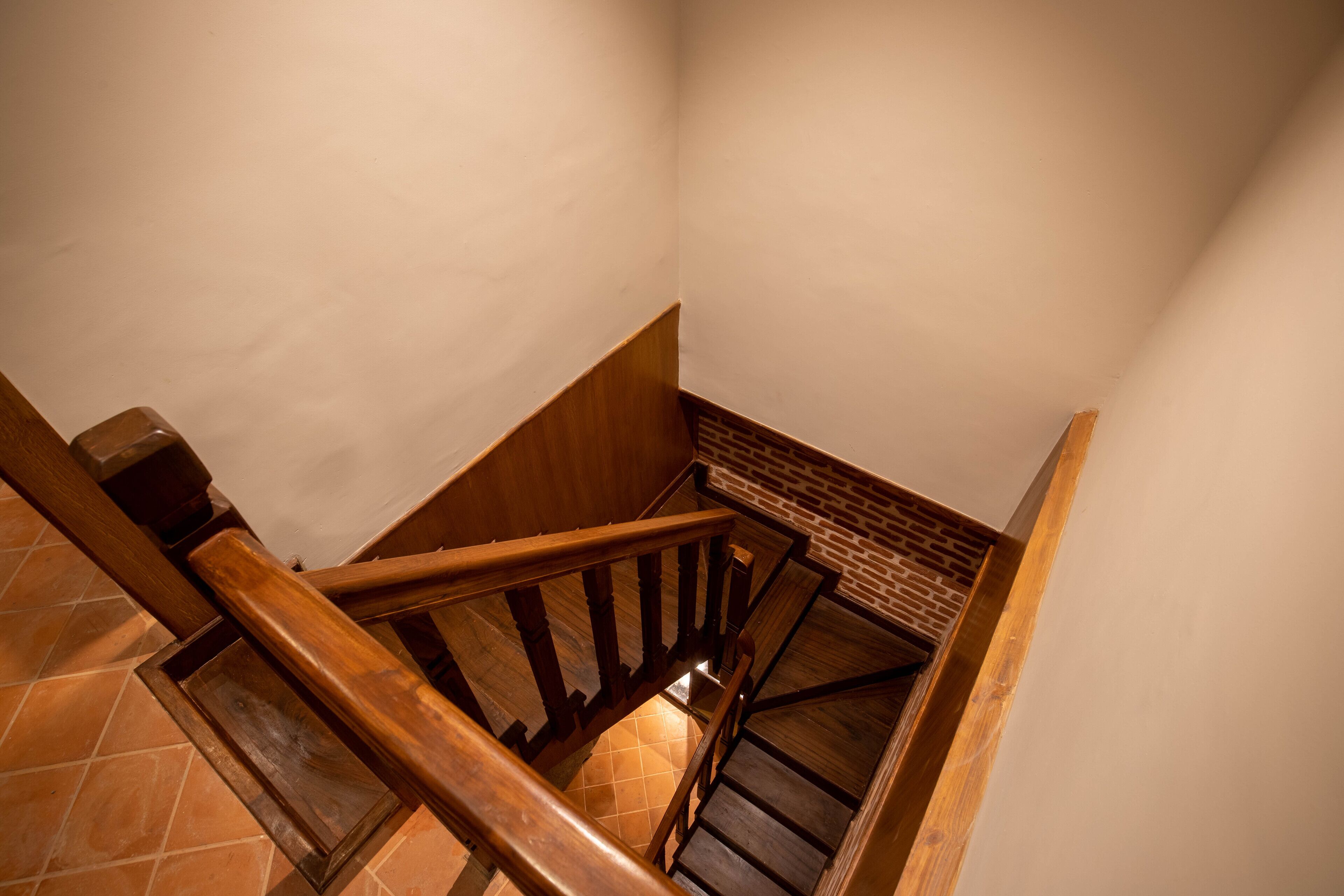 Una escalera de madera con una pared de ladrillo en la parte inferior.