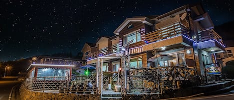 Vista frontal de la propiedad por la tarde o noche