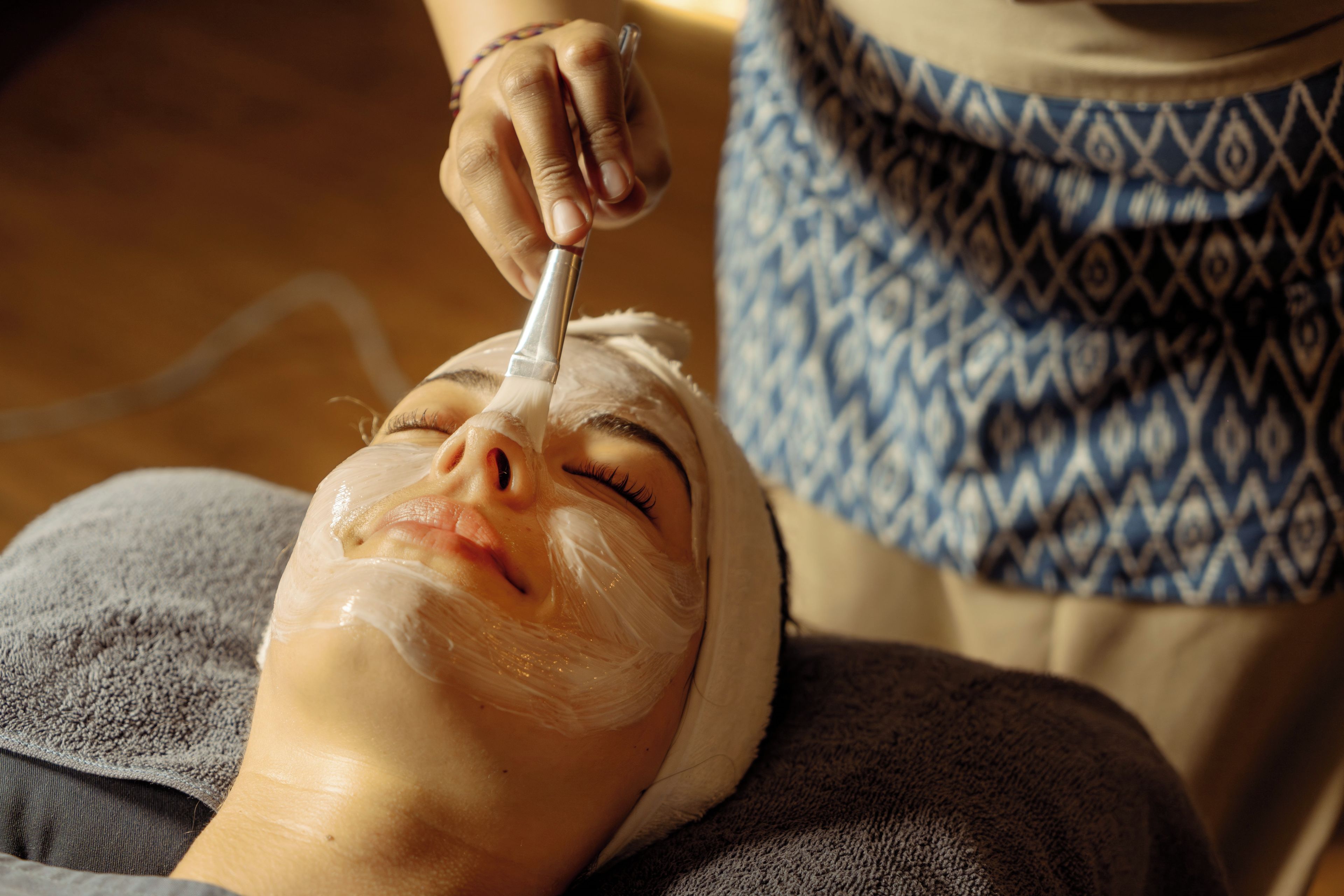 Una persona acostada con un dispositivo en el rostro, posiblemente para un tratamiento facial.