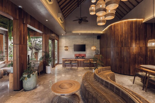 A modern interior with a wooden ceiling, a bar area, and seating arrangements. - Sini Vie Resort & Spa Seminyak by Ini Vie Hospitality (Keroboken Kelod)