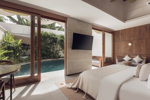 Ein Schlafzimmer mit einem großen Bett, einem Fernseher, einem Esstisch und Blick auf einen Swimmingpool.