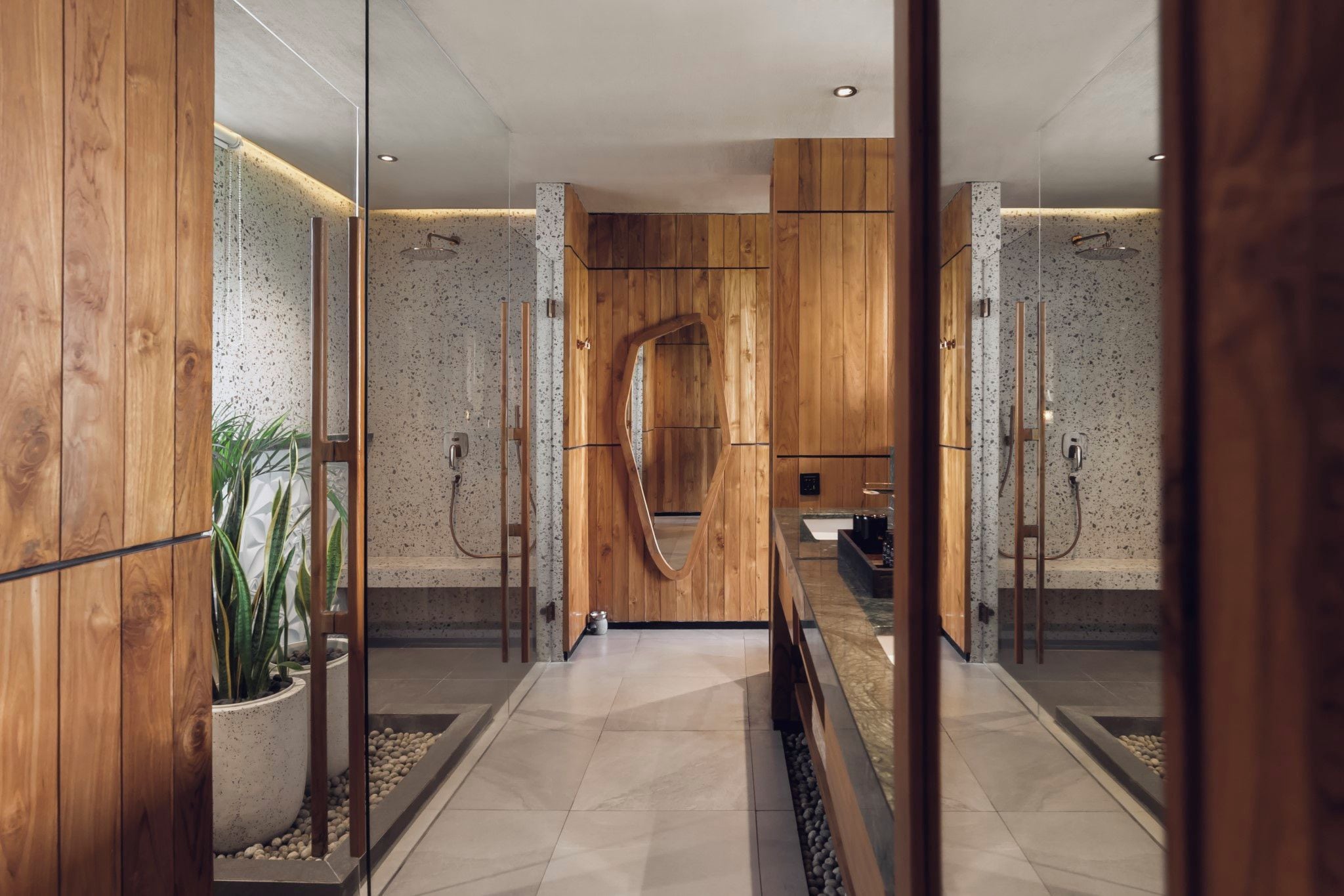 Een moderne badkamer met houten lambrisering, een glazen douchecabine en een marmeren vloer.