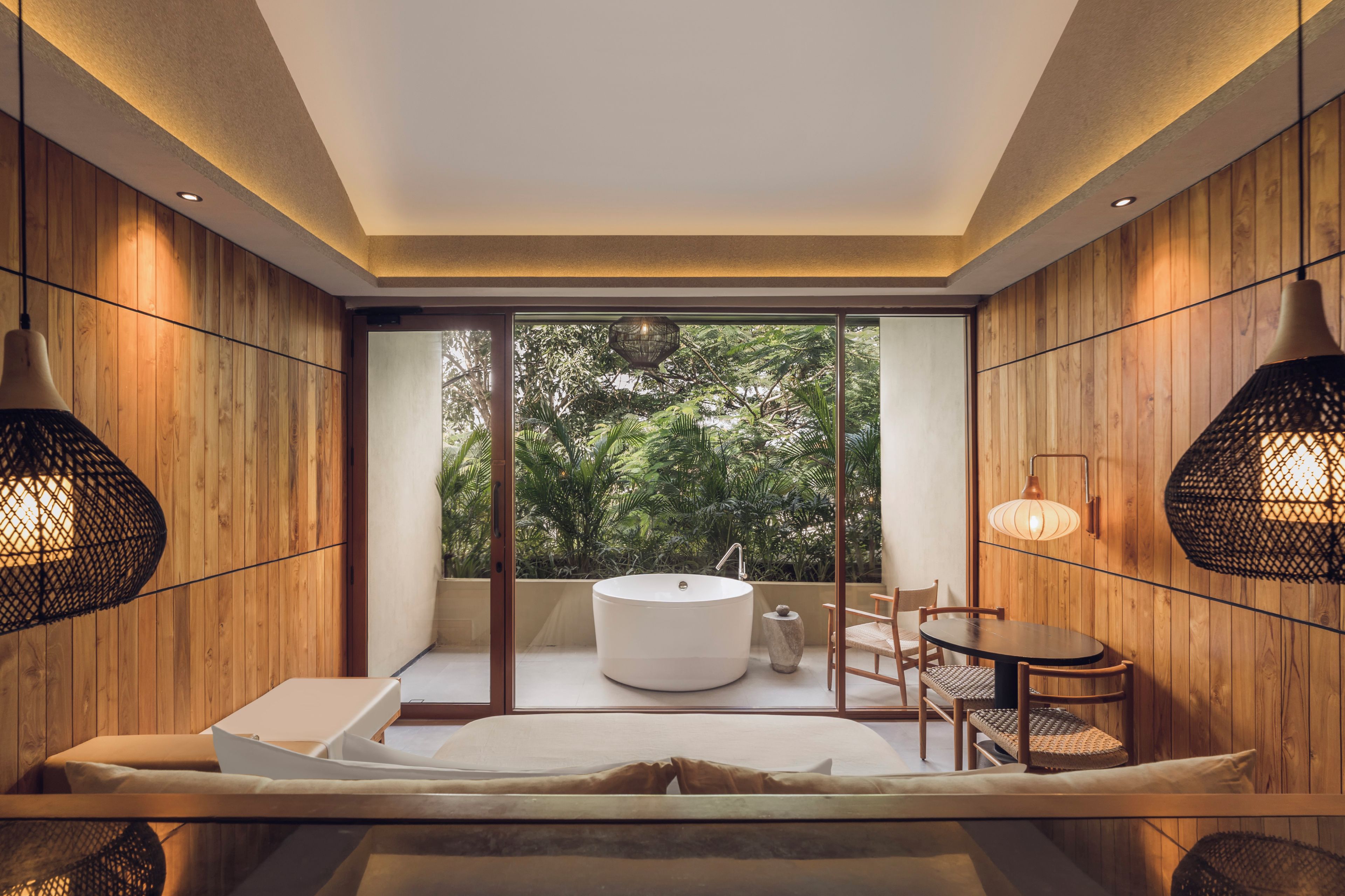 Un baño moderno con una bañera independiente, un ventanal amplio y paneles de madera.