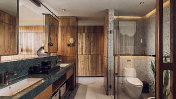 Ein modernes Badezimmer mit Holzvertäfelung, einem großen Spiegel, zwei Waschbecken und einer Toilette.