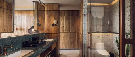 A modern bathroom with wooden paneling, a large mirror, two sinks, and a toilet.