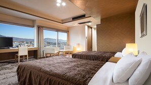 Una habitación de hotel con dos camas, un escritorio y una televisión.