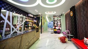 A hotel lobby with a reception desk, plush seating, and a Mickey Mouse statue. - Diu Diu Dang Family Homestay (Dongshan)