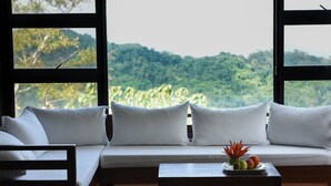 Una habitación con un sofá y una pequeña mesa con fruta.