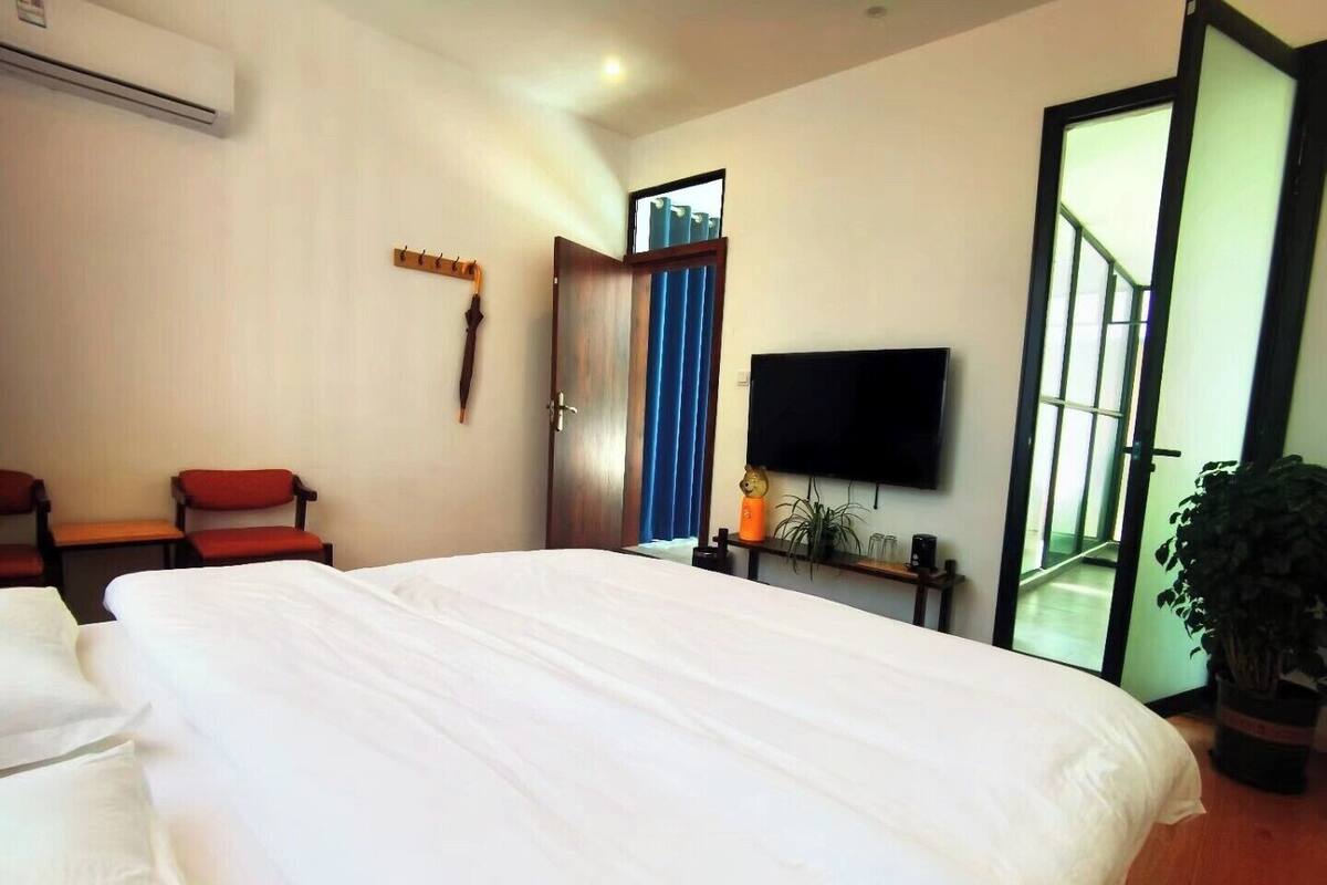 Une chambre d’hôtel avec un grand lit, une télévision, un bureau et une chaise.