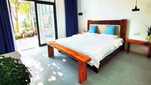 Une chambre à coucher moderne avec un lit en bois, une table de chevet et une plante en pot.