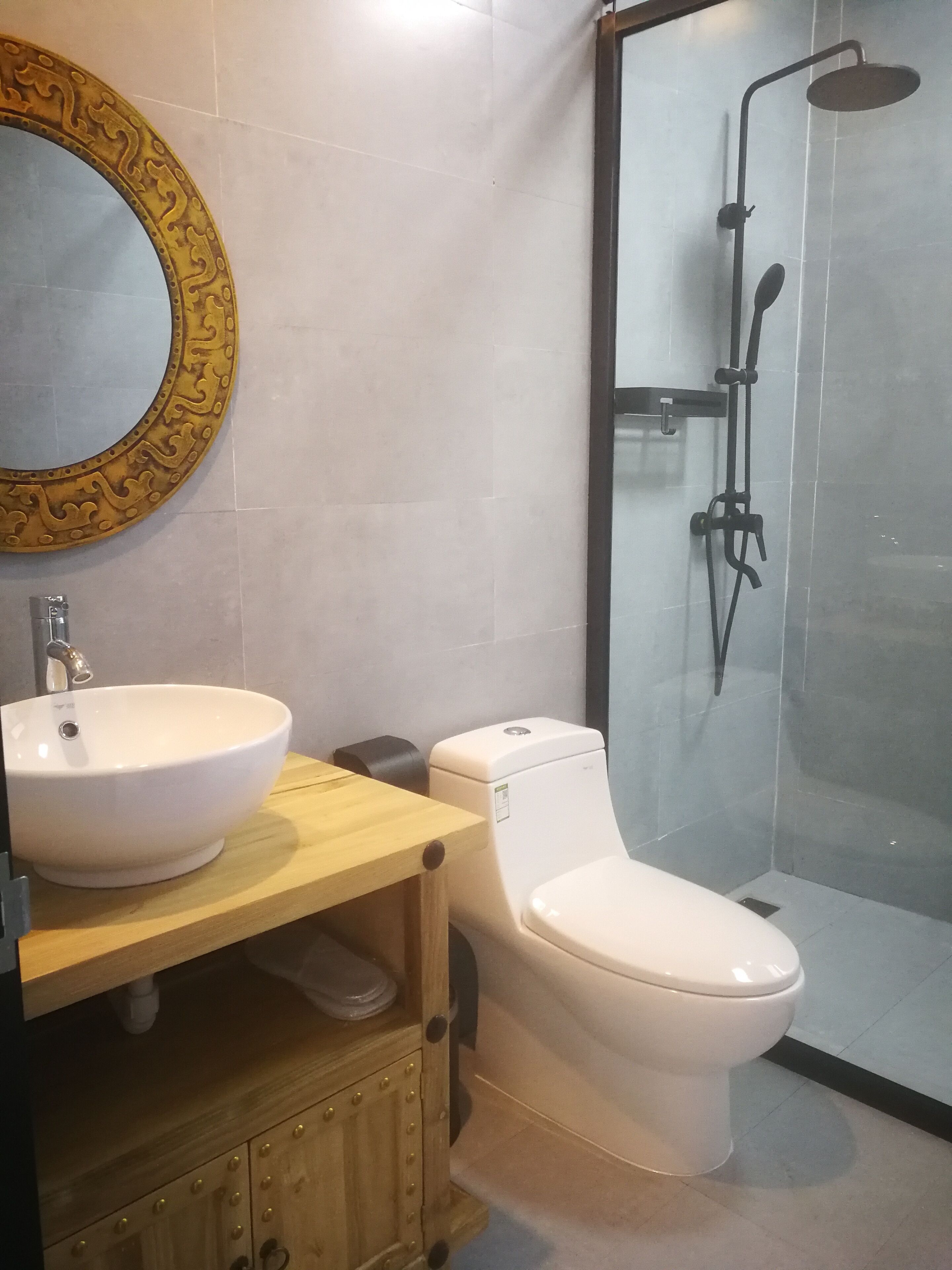 Een badkamer met een wit wastafelmeubel, toilet en douchecabine met glazen wanden.
