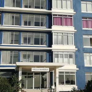 A multi-story building with balconies, large windows, and a sign reading "VILLA MARINA". - Villa Marina (Cape Town)