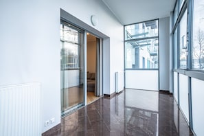 Un interior moderno con ventanas amplias, una puerta corrediza de vidrio y piso pulido.