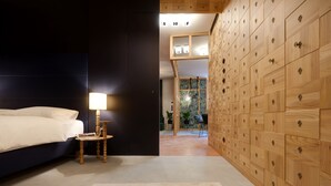 A bedroom with a bed, bedside table, lamp, and a large wooden wardrobe. - Goldengel Suite 2, 60sqm, air conditioning, WiFi (Kaltern)