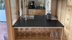 A kitchen with wooden cabinets, a black countertop, and various kitchen appliances. - Goldengel Suite 2, 60sqm, air conditioning, WiFi (Kaltern)