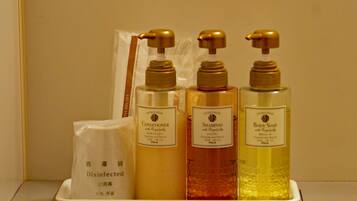 A tray with three bottles of toiletries and a disinfected bag.