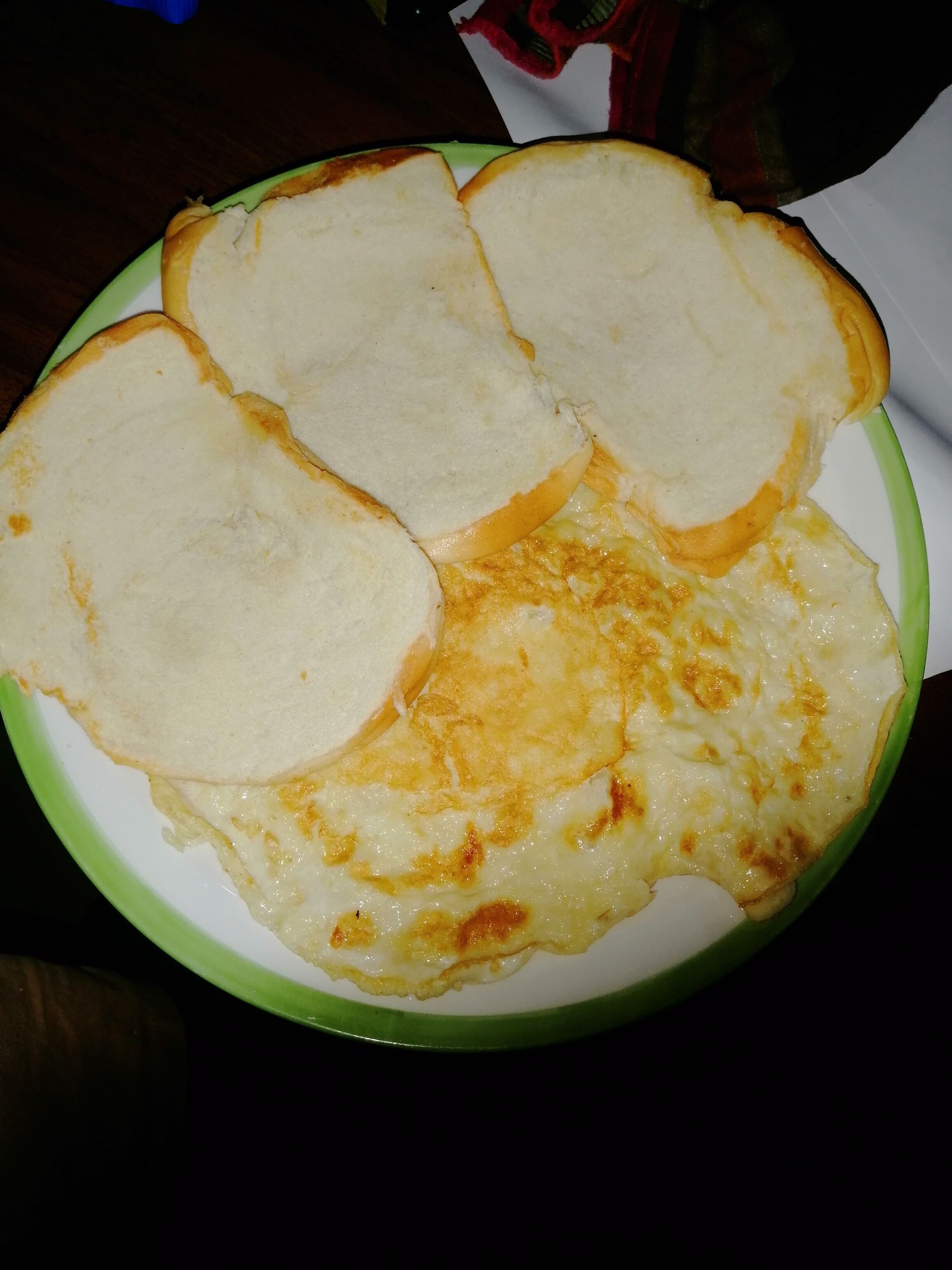 A plate with a dish that includes bread and a creamy, cheesy topping.