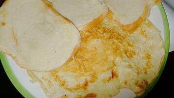 A plate with a dish that includes bread and a creamy, cheesy topping.