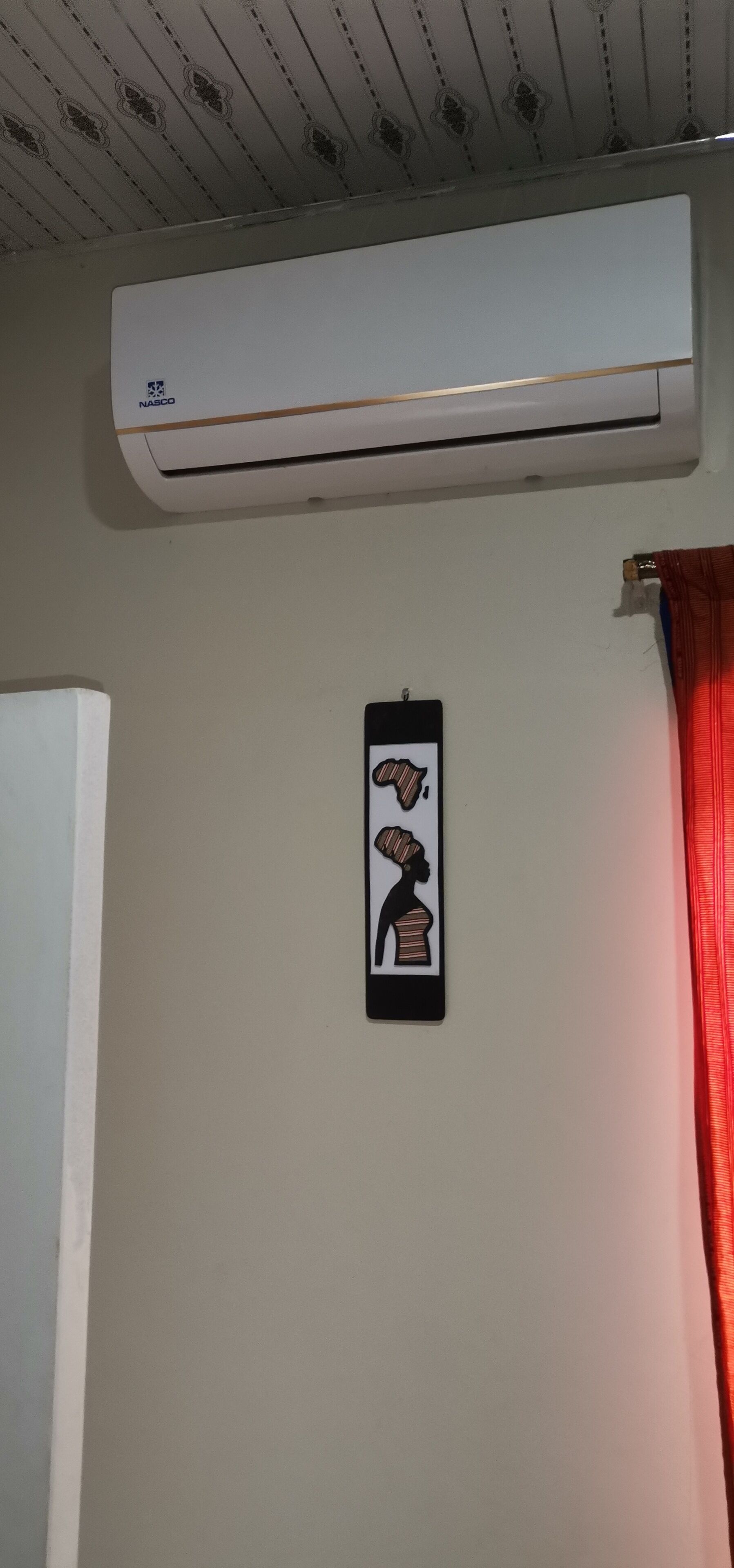 Eine Klimaanlage an der Wand, darunter ein dekorativer Gegenstand.