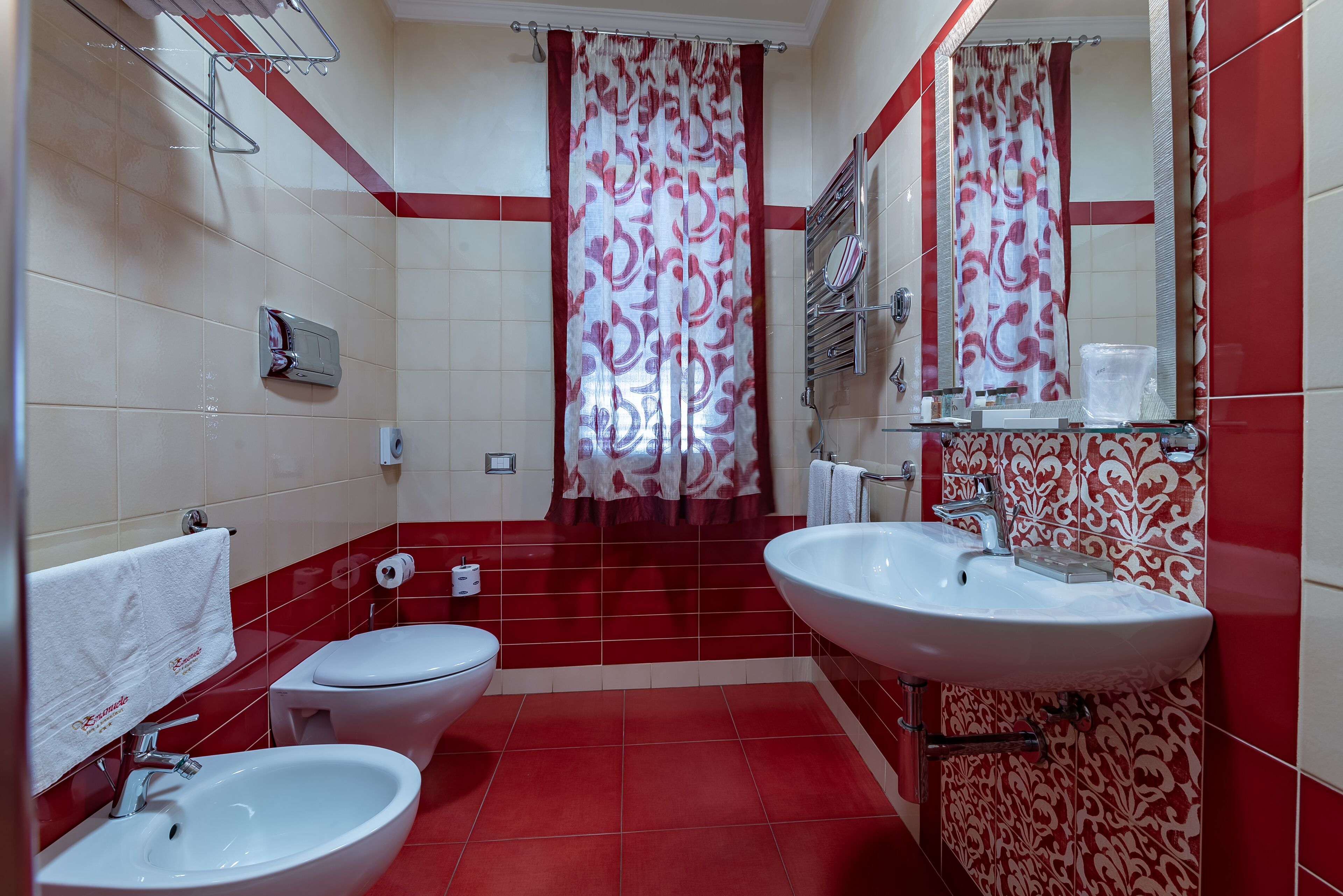 A bathroom with two sinks, a toilet, and a shower area.