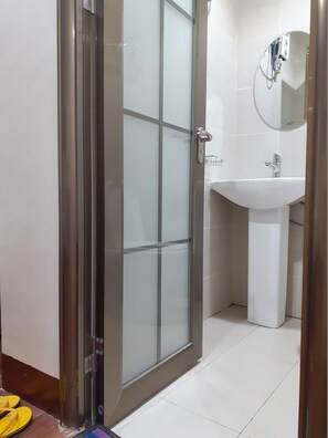 Bathroom features a glass shower enclosure, pedestal sink, and wall-mounted towel rack.