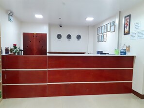Reception area features a reception desk with a flat top surface, wall clocks displaying various time zones, and framed artwork.