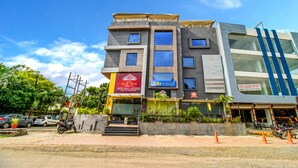 Un immeuble à plusieurs étages, avec un restaurant au rez-de-chaussée et une enseigne indiquant qu’il y a des locaux disponibles à la location.