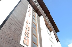 Un edificio con fachada de madera y un letrero que dice "FOSSIL".