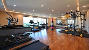 Un gimnasio amplio con cintas de correr, elípticas, un saco de boxeo y una zona de pesas.
