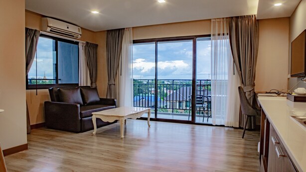 Un salón amplio con un sofá, una mesa de centro y un balcón con vistas.