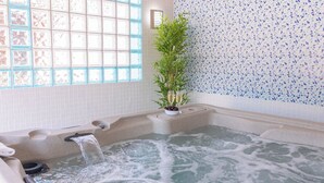 Ein Whirlpool mit Fenster und einer Mosaikwand.