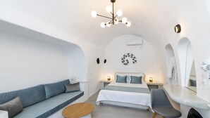 Ein modernes, minimalistisches Schlafzimmer mit Sofa, Bett und Sitzecke.