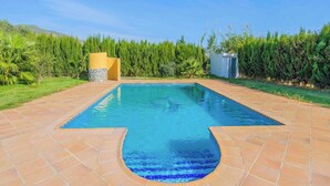 A rectangular pool with a unique shape, surrounded by a tiled patio. - La Chumbera Órgiva by Ruralidays (Granada)