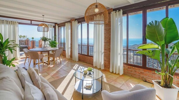 Ein geräumiger Balkon mit Essbereich, großen Fenstern und Meerblick.