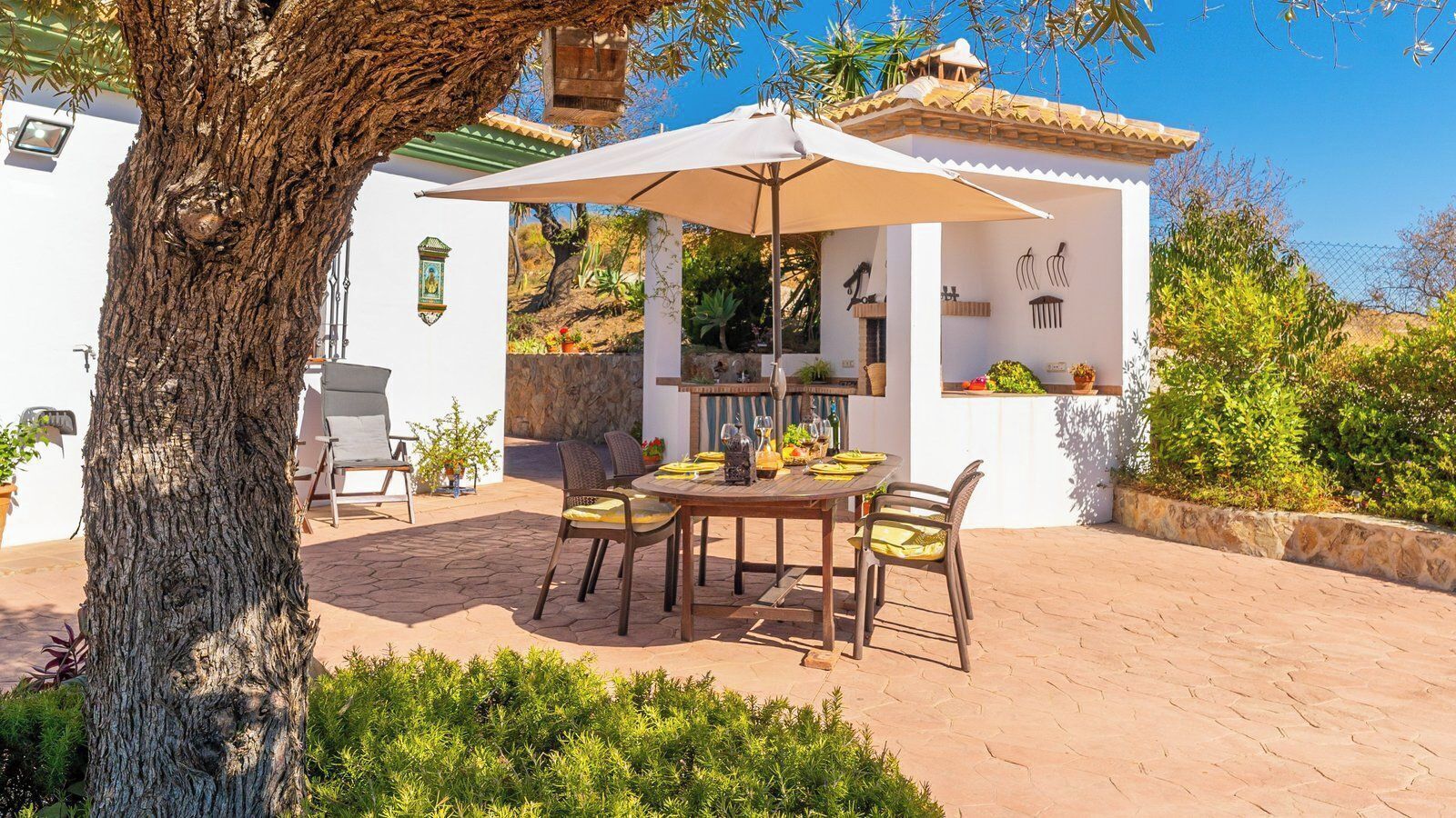 An outdoor patio with a round table, chairs, and a pergola.