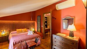 A hotel room with a large bed, a wooden dresser, a mirror, and a lamp. - Zulaikhah Suite Ronda by Ruralidays (Málaga)