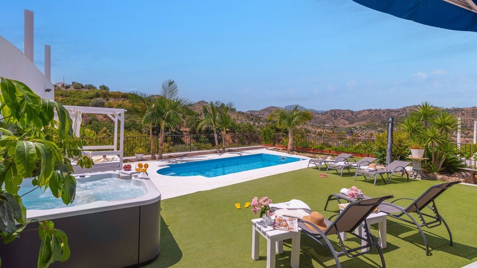 Un pati interior amb piscina, gandules i banyera hidromassatge.