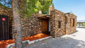 A stone building with a wooden door and a small porch area. - Los Albardinales -  Casa Blanqueta Tabernas by Ruralidays (Almería)