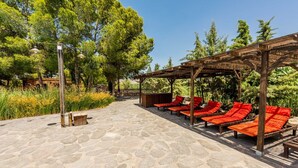 A covered outdoor seating area with stone flooring and wooden pergola. - Los Albardinales -  Casa Blanqueta Tabernas by Ruralidays (Almería)
