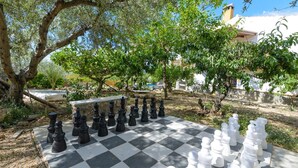 A chessboard set outdoors with trees in the background. - Cortijo Los Tulipanes Periana by Ruralidays (Málaga)