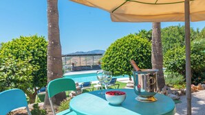 An outdoor seating area with a pool, a table with a drink, and a view of the mountains. - Cortijo Los Tulipanes Periana by Ruralidays (Málaga)