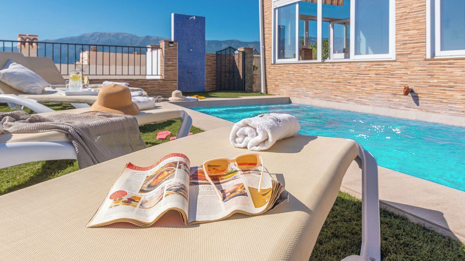 A poolside area with lounge chairs, a magazine, and a towel.