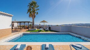 A rooftop pool with clear blue water, a palm tree, and a view of distant mountains. - Balcon de la Axarquia Almáchar by Ruralidays (Málaga)