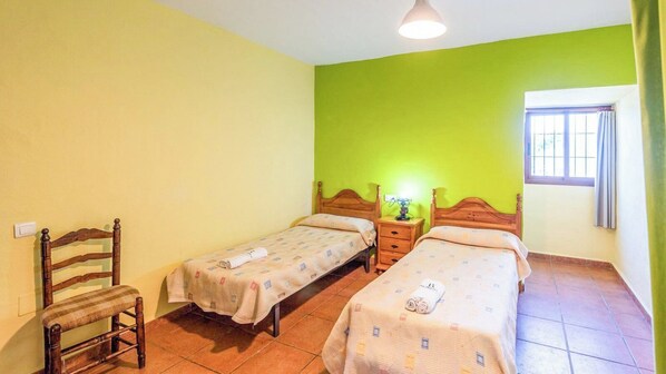 A room with two single beds, a wooden chair, and a small bedside table with a lamp. - Alejandro de Almachar Almáchar by Ruralidays (Málaga)