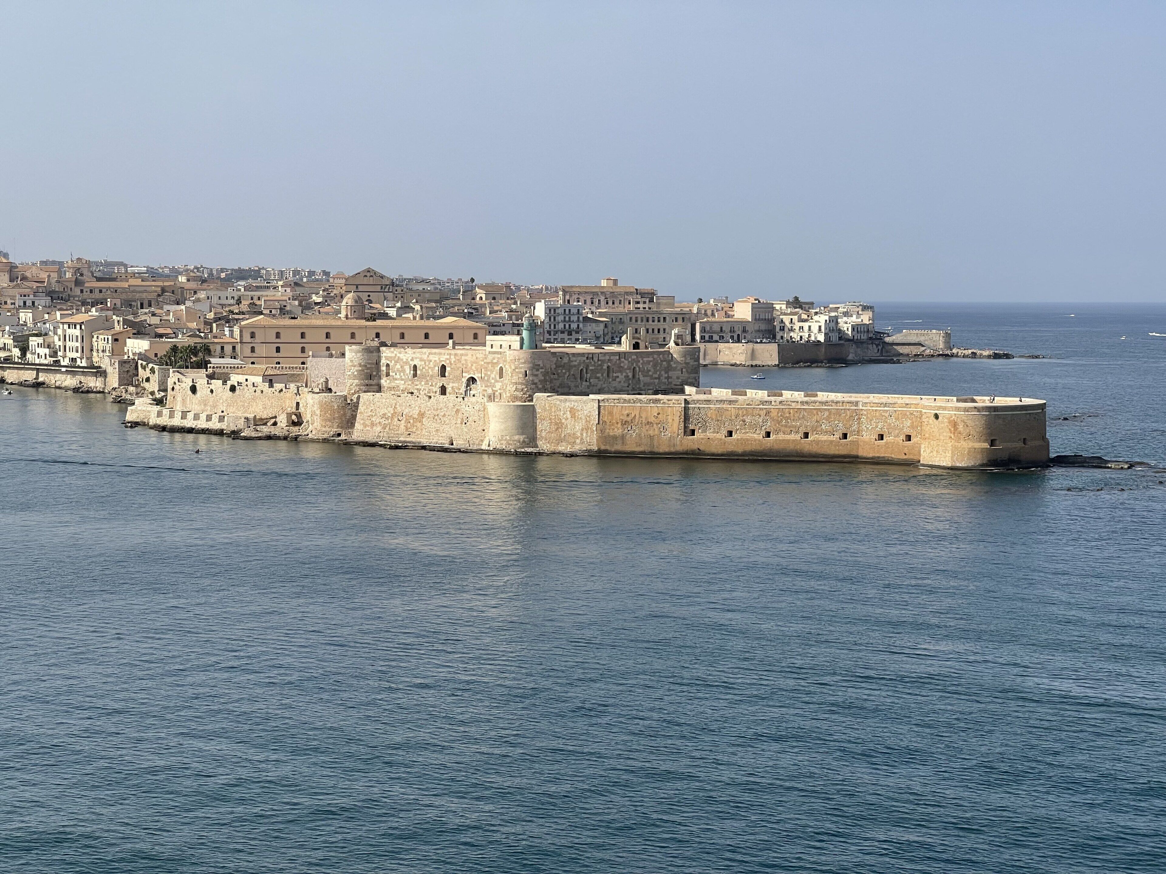 A fortified coastal city with historic stone walls and buildings.