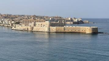 A fortified coastal city with historic stone walls and buildings.