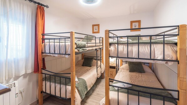 A dormitory room with bunk beds, a window with curtains, and a small bedside table. - Villa Muñoz Ronda by Ruralidays (Málaga)